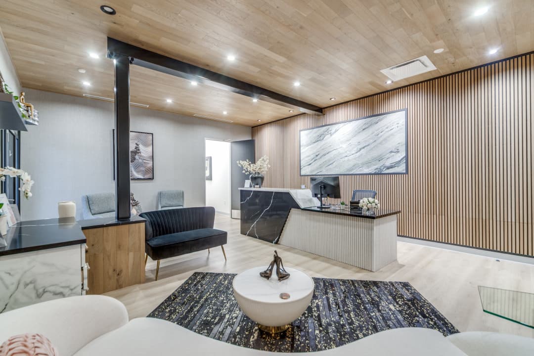 Reception area with wood accent wall, front desk, and lounge seating