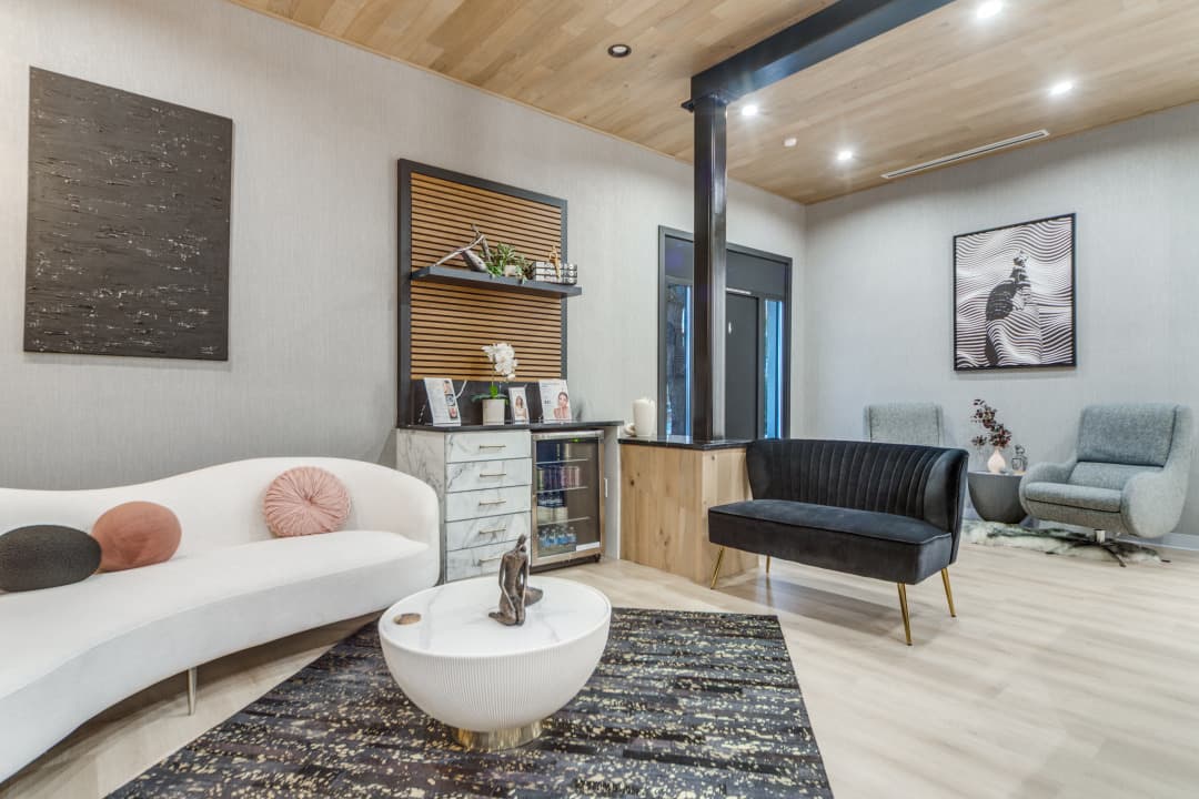 Office lounge area with curved sofa, chairs, and wall art