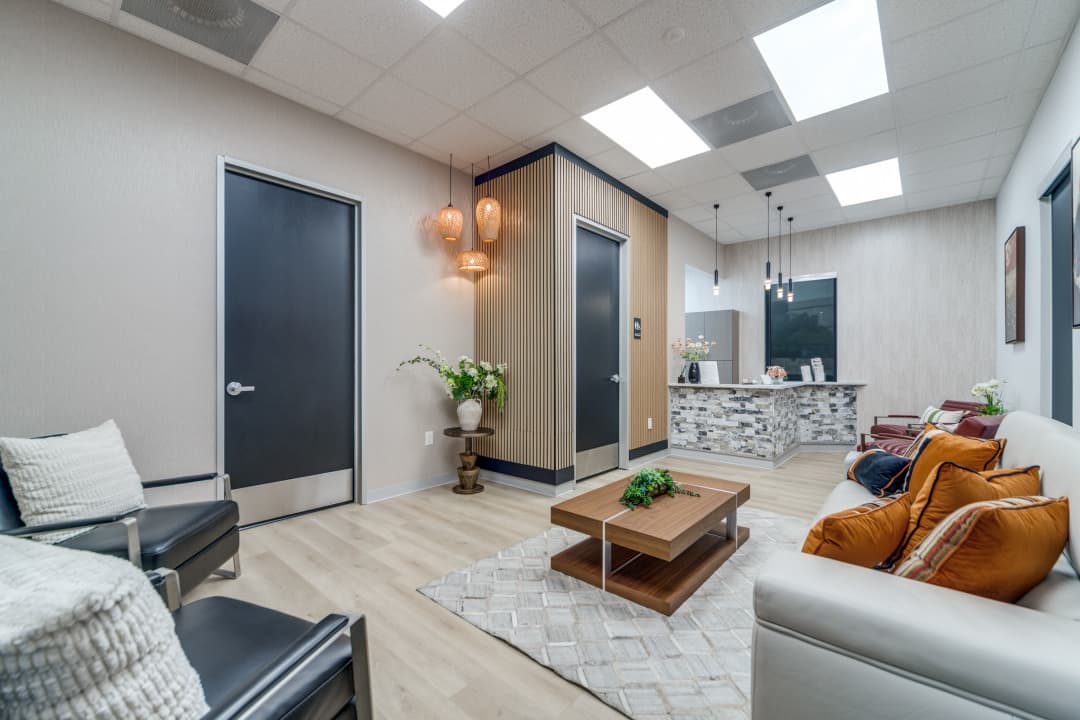Waiting room with front desk, seating, and pendant lighting
