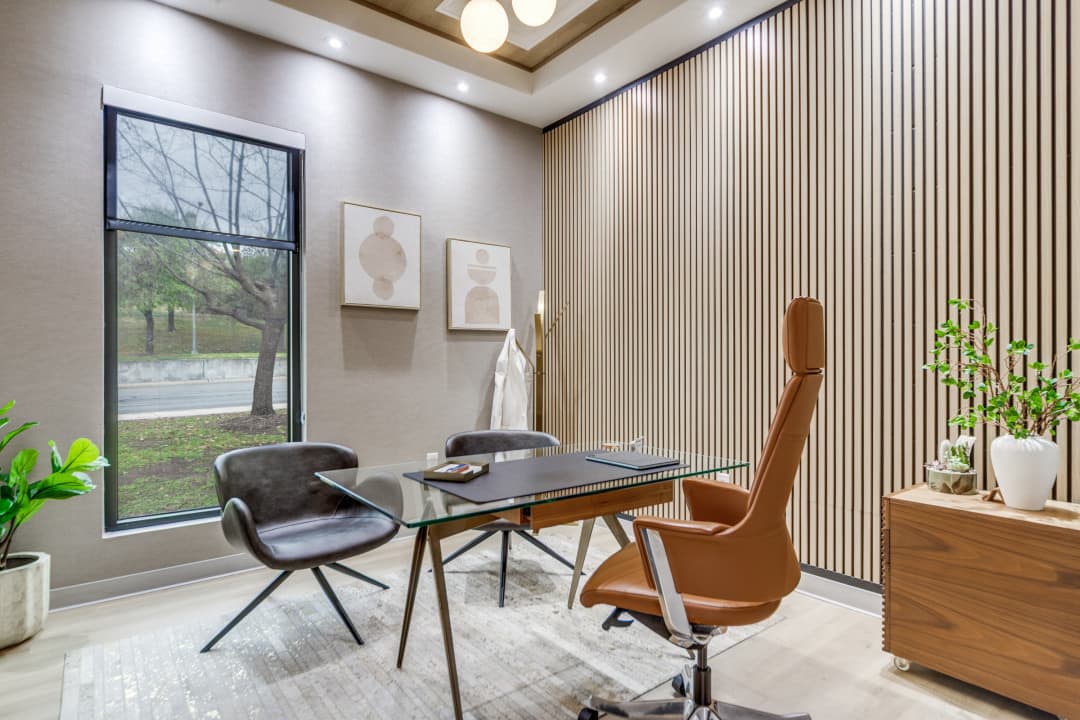 Consultation room with glass desk and wood accent wall