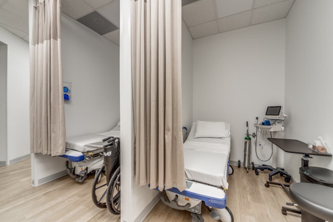 Patient care area with curtained treatment bays and medical beds