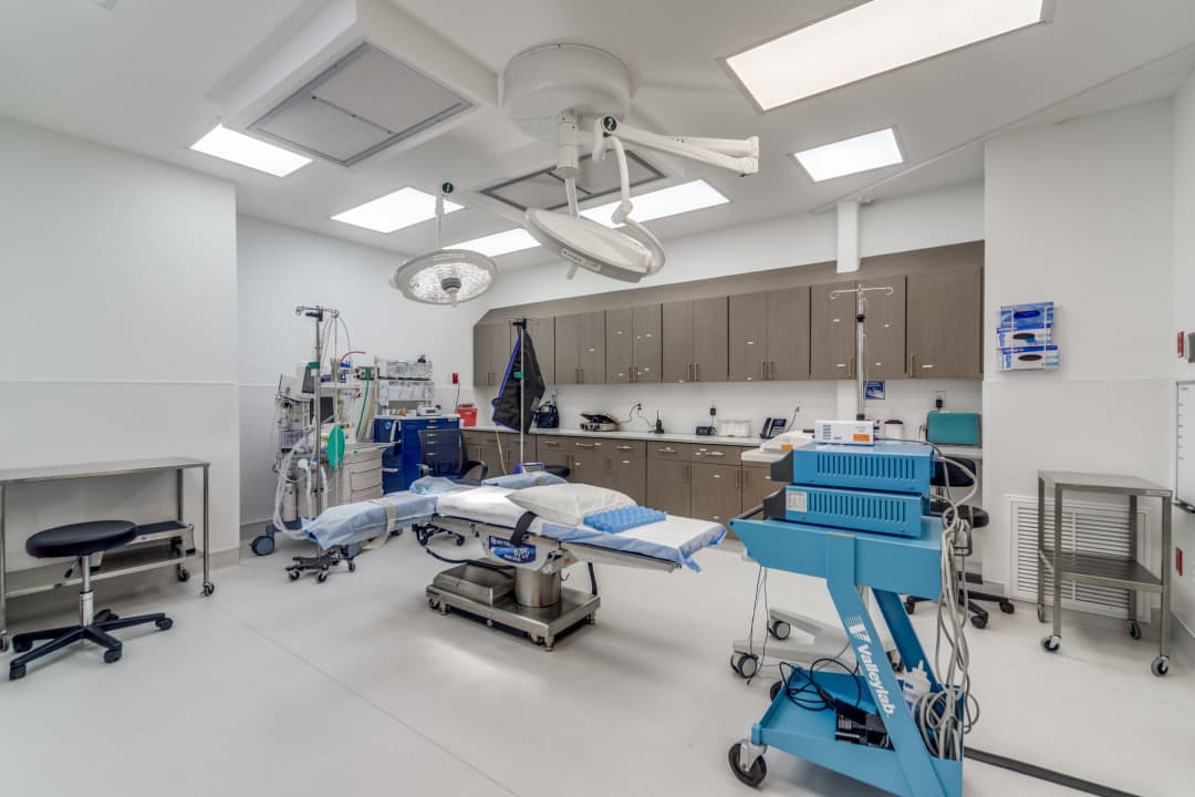 Operating room with surgical table, overhead lights, and medical equipment
