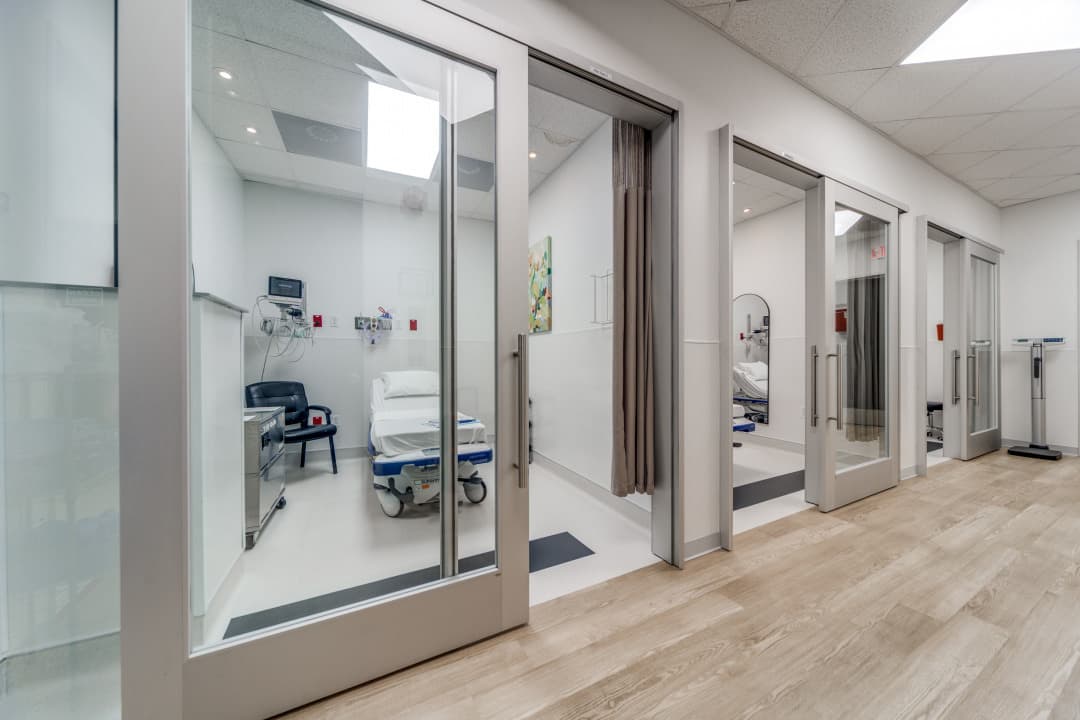 Hallway with glass doors leading to patient care rooms