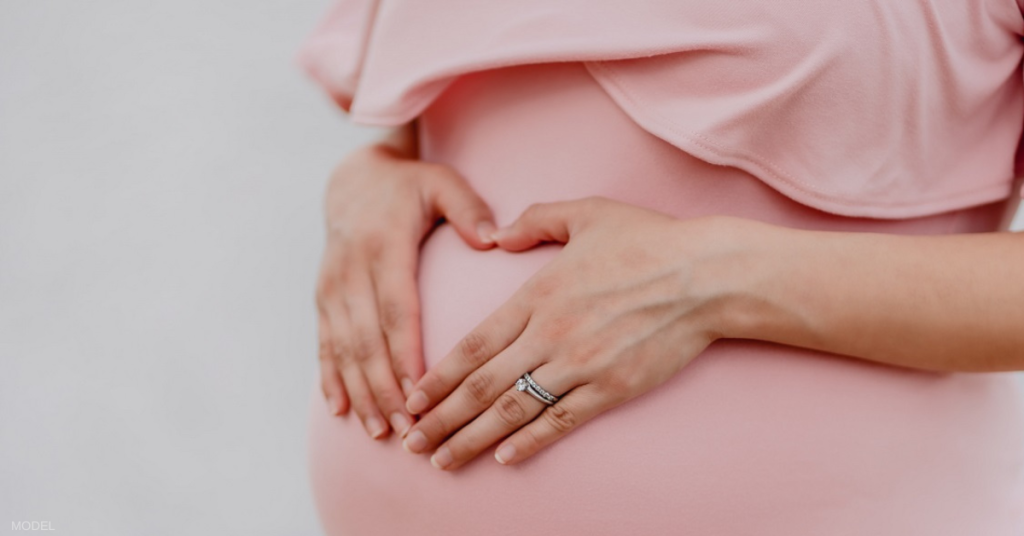 Pregnant woman with her hands on her stomach (model)