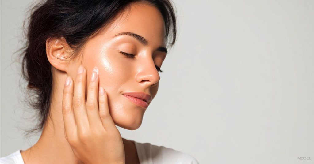 Close up of a woman's face with dewy skin. (Model)