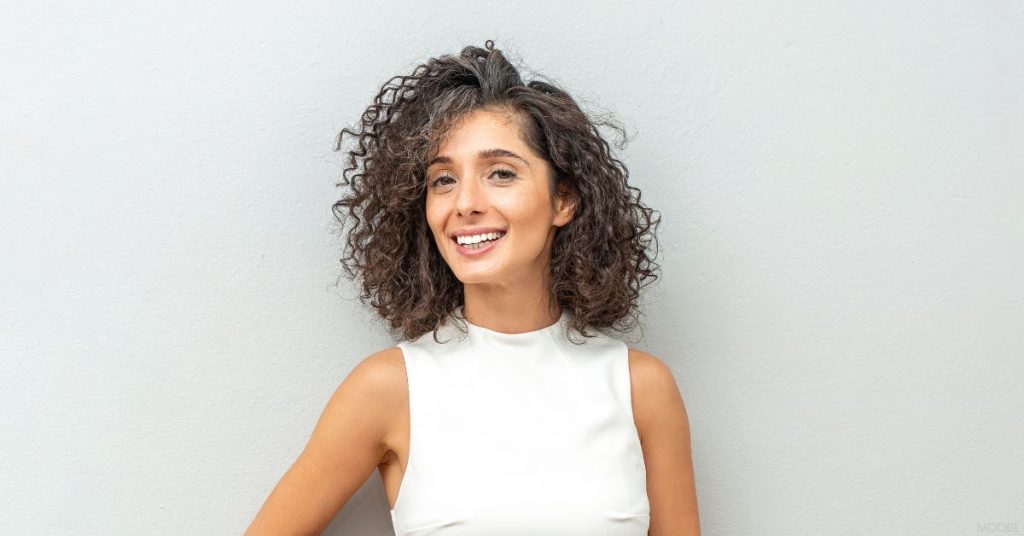 Mature woman smiling post deep plane facelift and neck lift surgery (model)