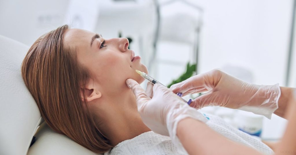 Woman receiving a dermal filler treatment (models)