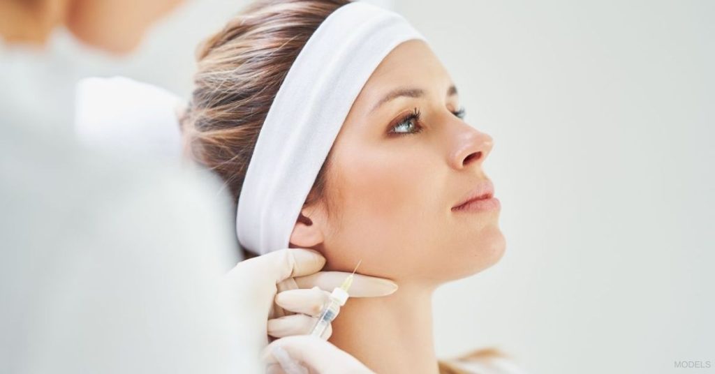 Woman receiving dermal fillers. (Models)